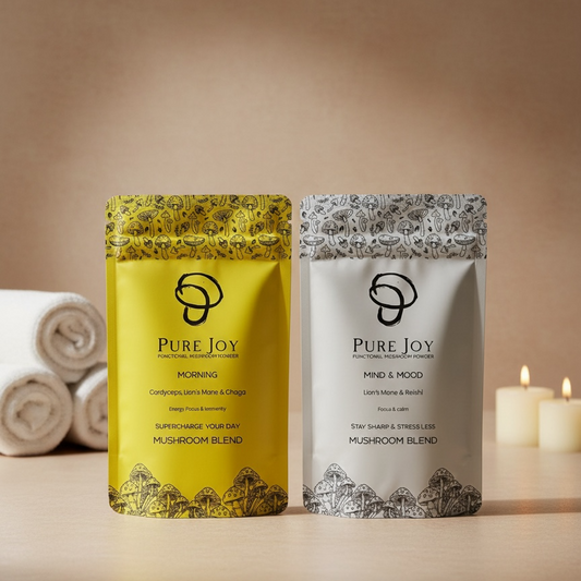 Two packages of Pure Joy mushroom blends on a wooden surface with candles and towels in the background.
