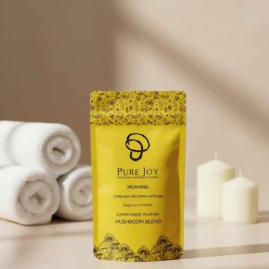 Yellow package labelled 'Pure Joy Morning Blend' on a neutral background with towels and candles.