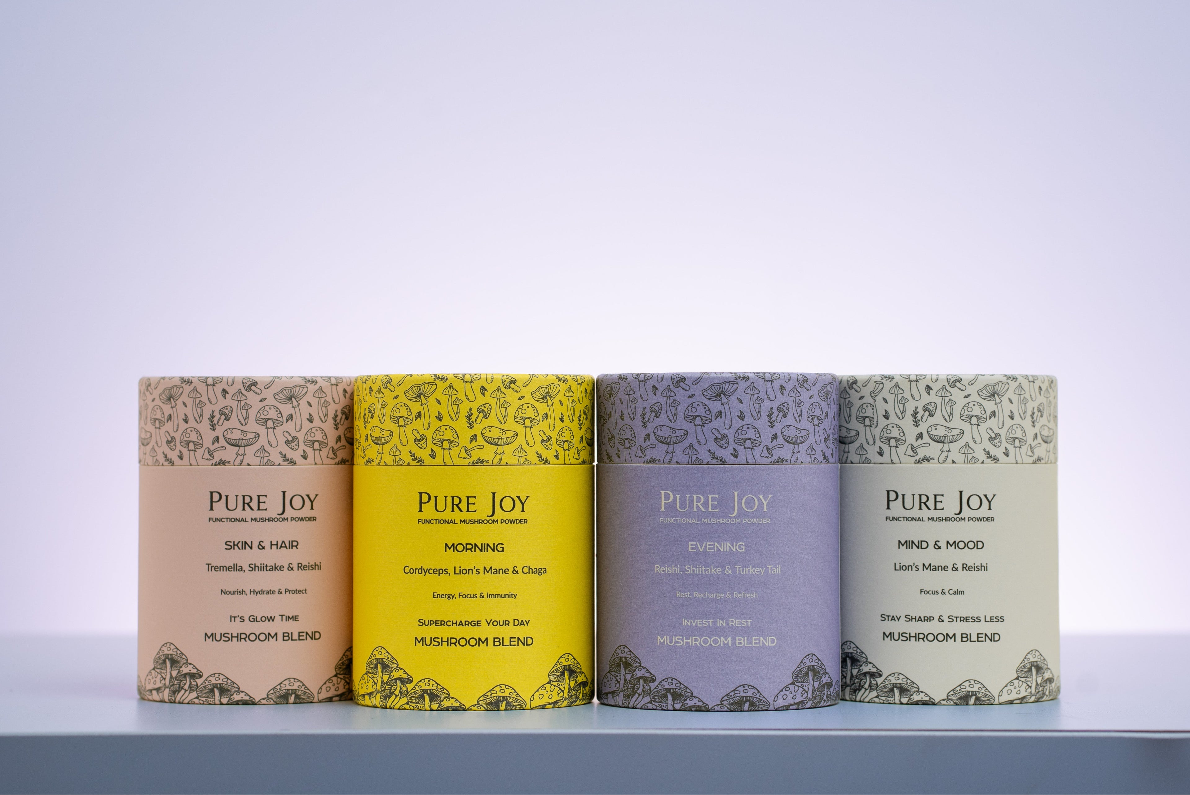 Four 'Pure Joy' mushroom tubs in different colours on a white surface with a light grey background