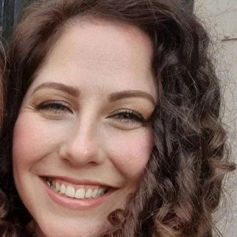 Close-up of a woman with wavy hair against a neutral background